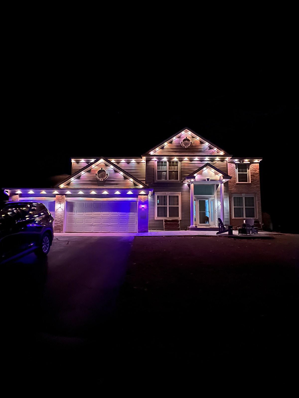 Two-story house lit in purple and white
