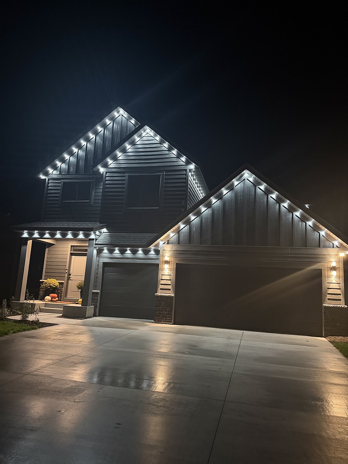 Dark farmhouse outlined in warm white lights